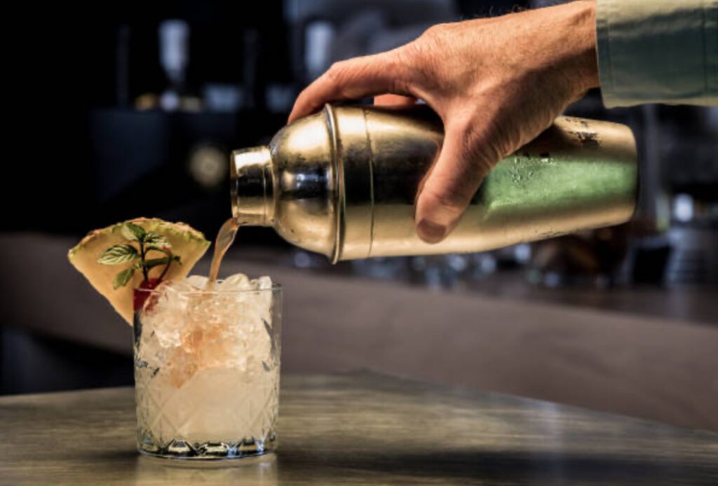 Bartender pouring signature cocktail at mobile bartending in League City event