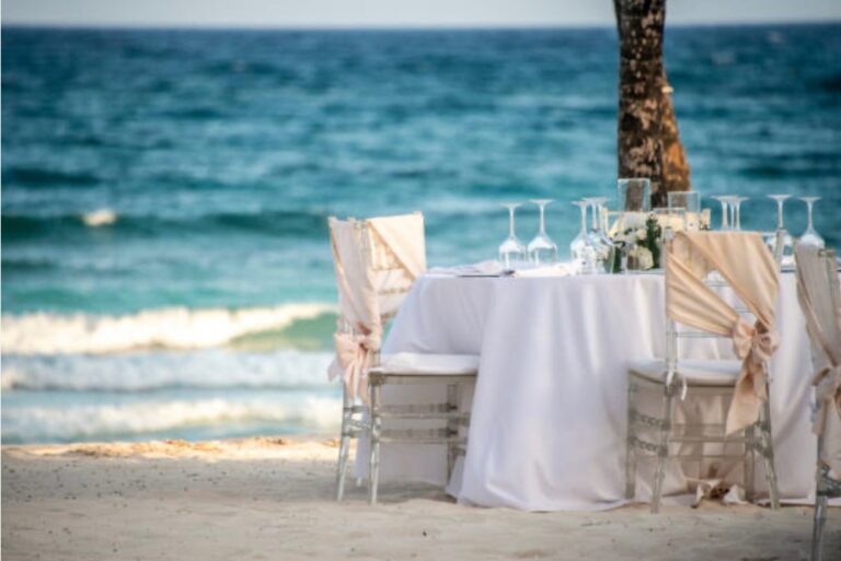 Elegant beach wedding reception table setup with cocktails