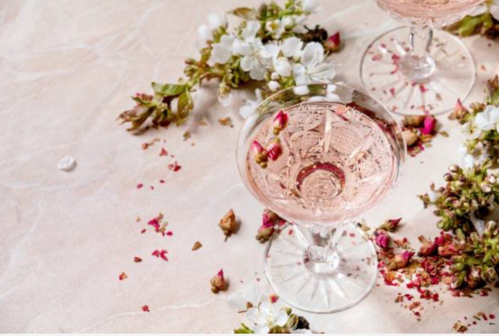Blush pink champagne cocktail with floral garnish