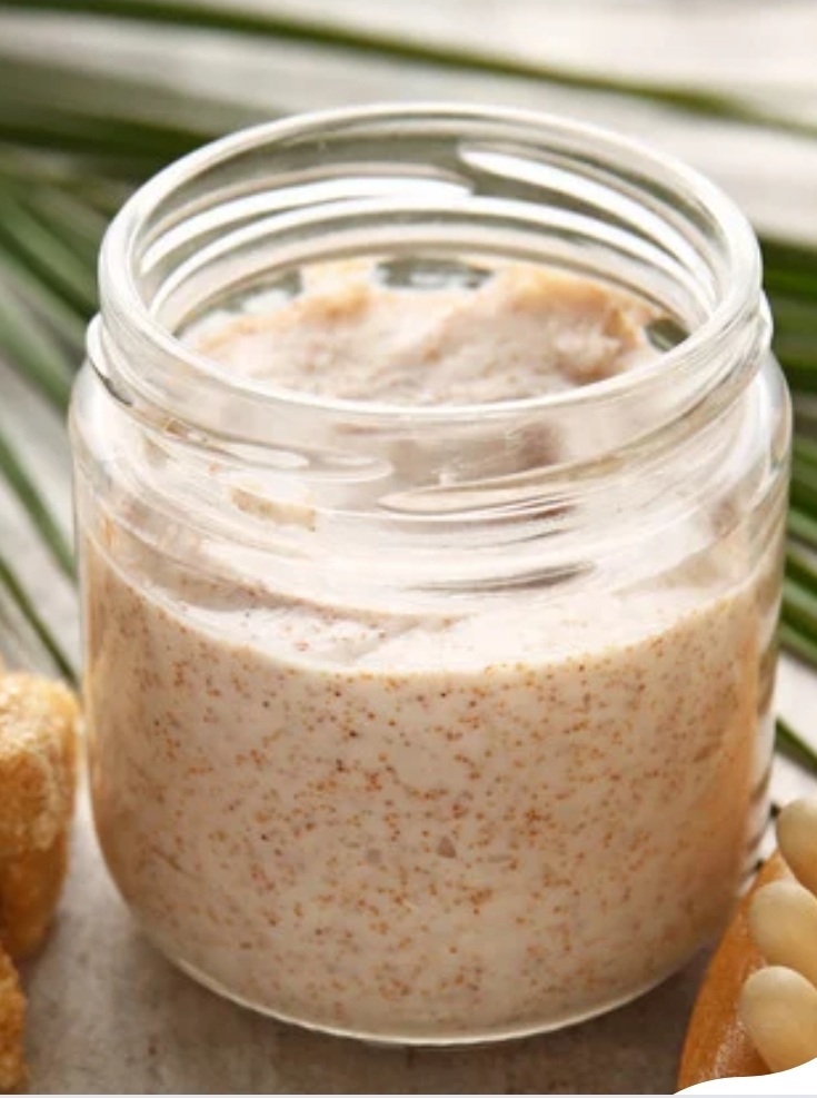 Whipped brown sugar body scrub in a clear glass jar with natural ingredients