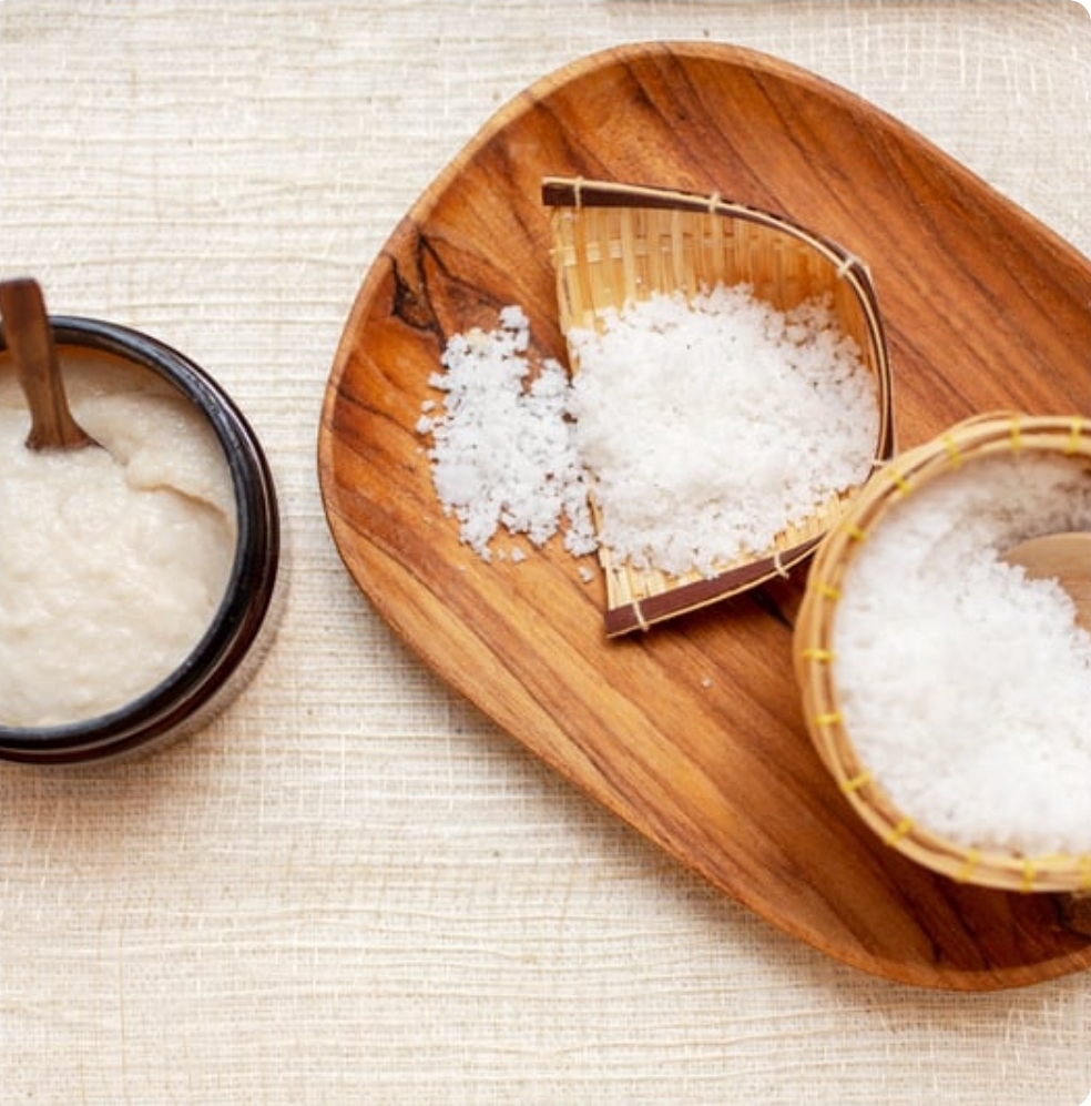 Natural sea salt scrub displayed in bamboo bowls on a wooden tray