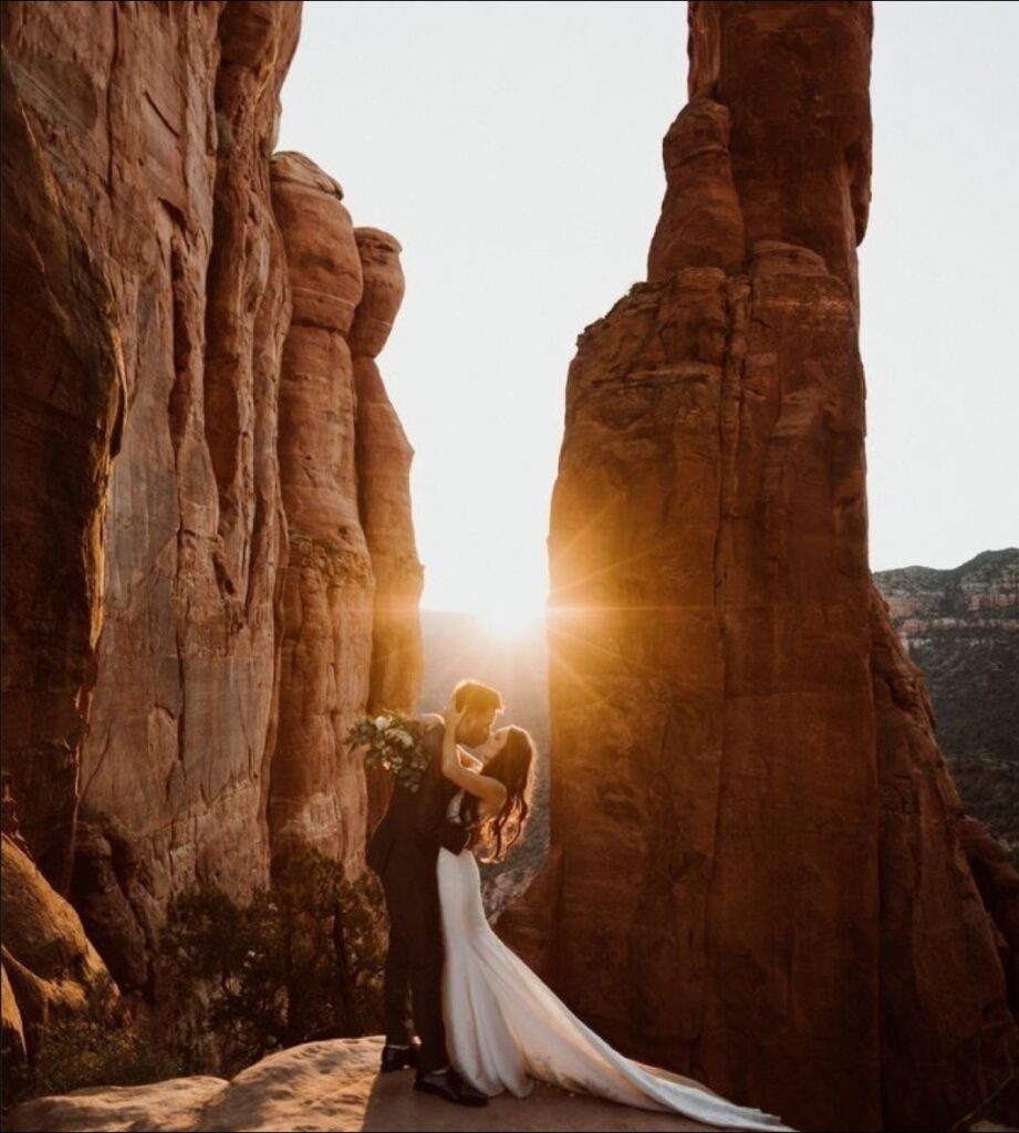 Romantic wedding kiss at sunset between red rock canyons